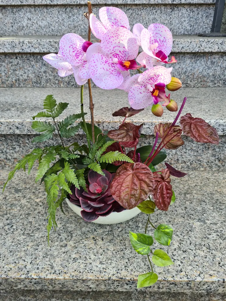 [import] Gesteck mit Orchideen in Schale